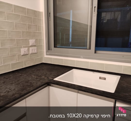 מטבח משופץ עם כיור חדש ומשטח עבודה כהה
